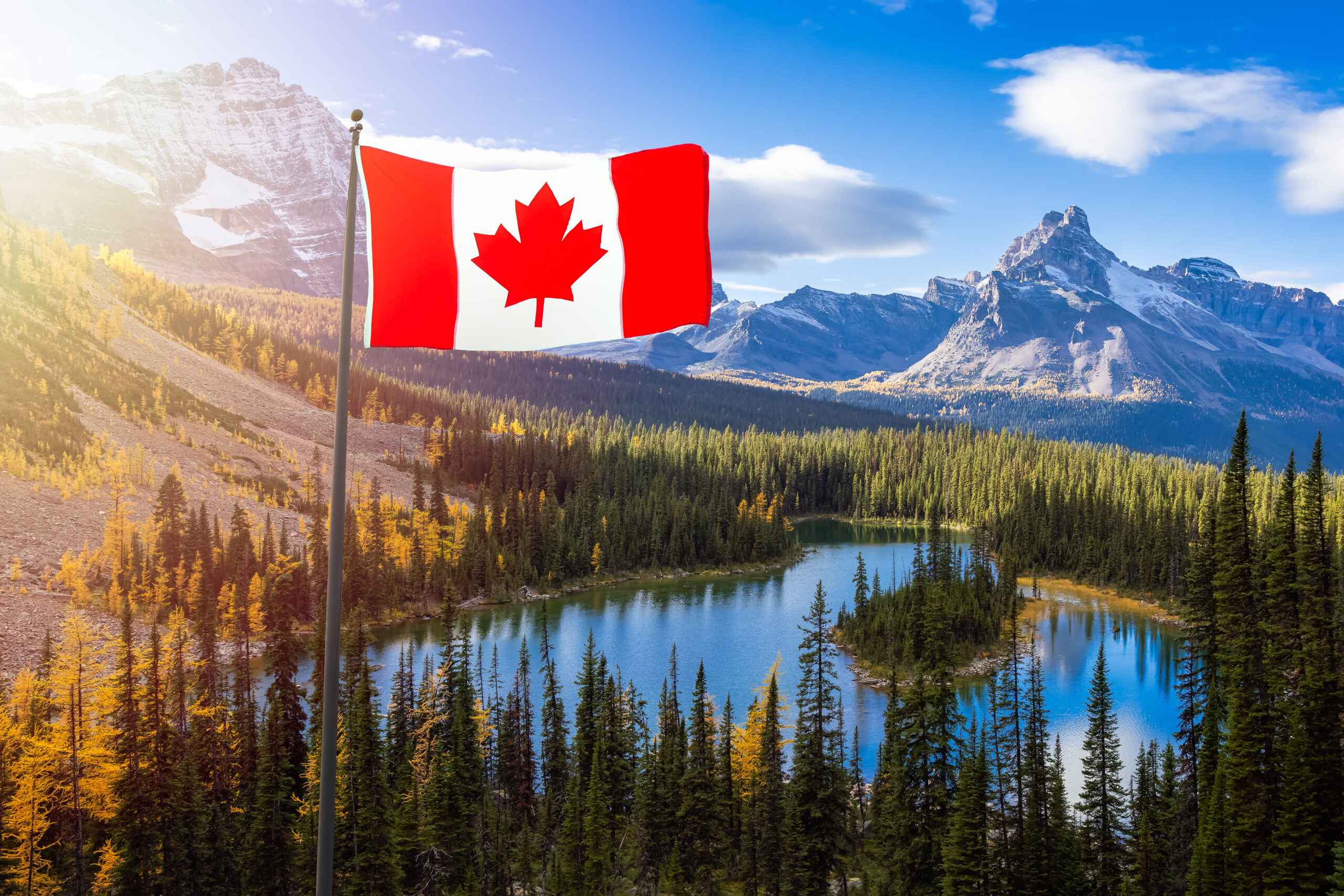 Canadian National Flag Composite with Canadian Rocky Mountains in Background. Sunny Fall Day. Located in Lake O'Hara, Yoho National Park, British Columbia, Canada.